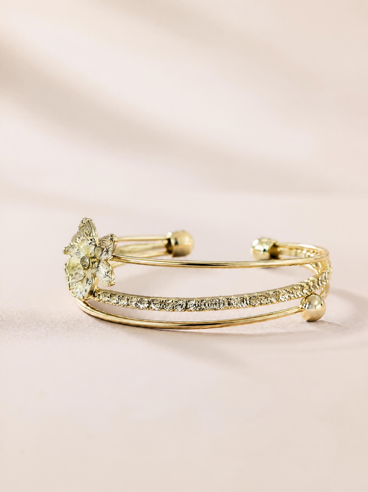 Bracelet manchette doré SYERA avec fleur en zircons, gros plan bijou