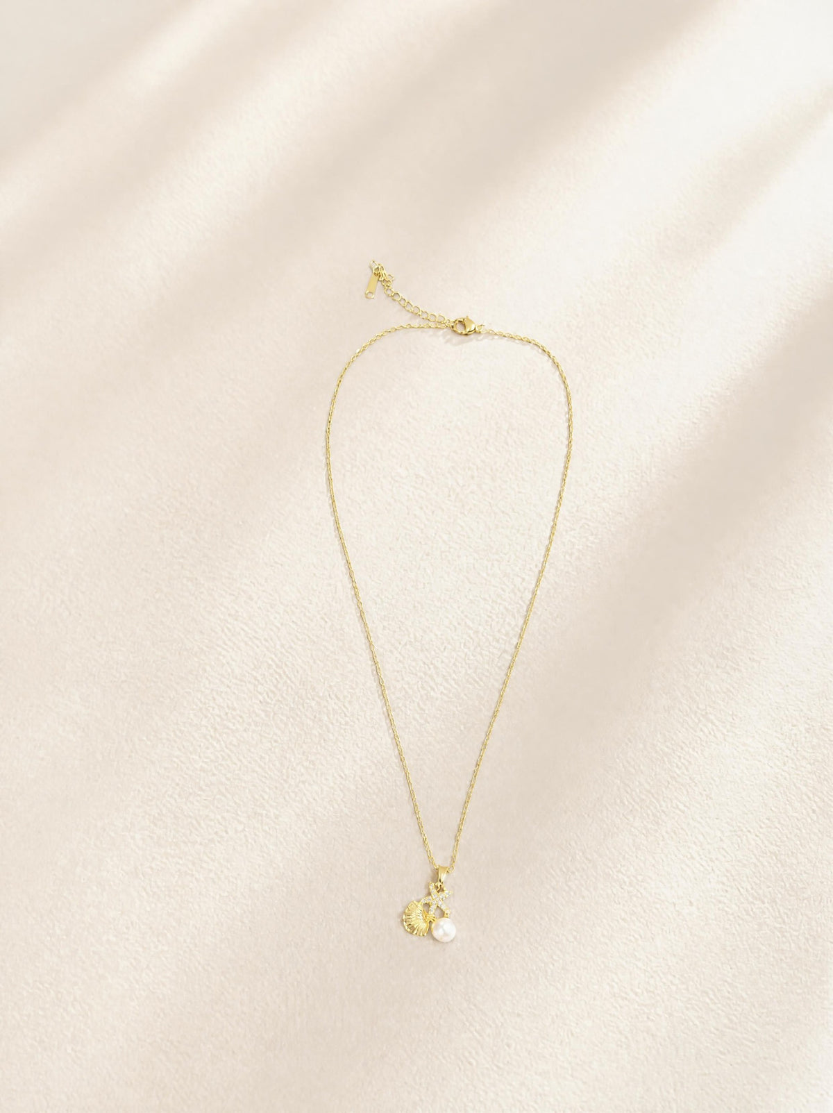 Collier trésor de mer SYERA, gros plan pendentif doré coquillage et perle
