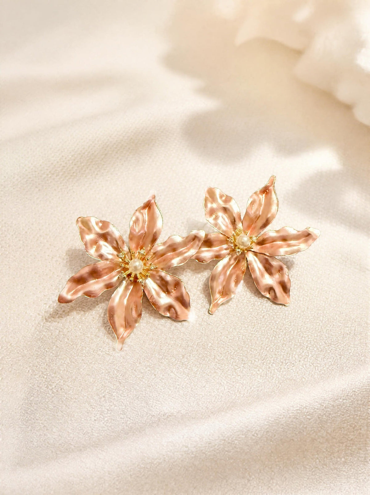 Boucles d'oreilles fleur SYERA portées à l'oreille, détail perle et cristal