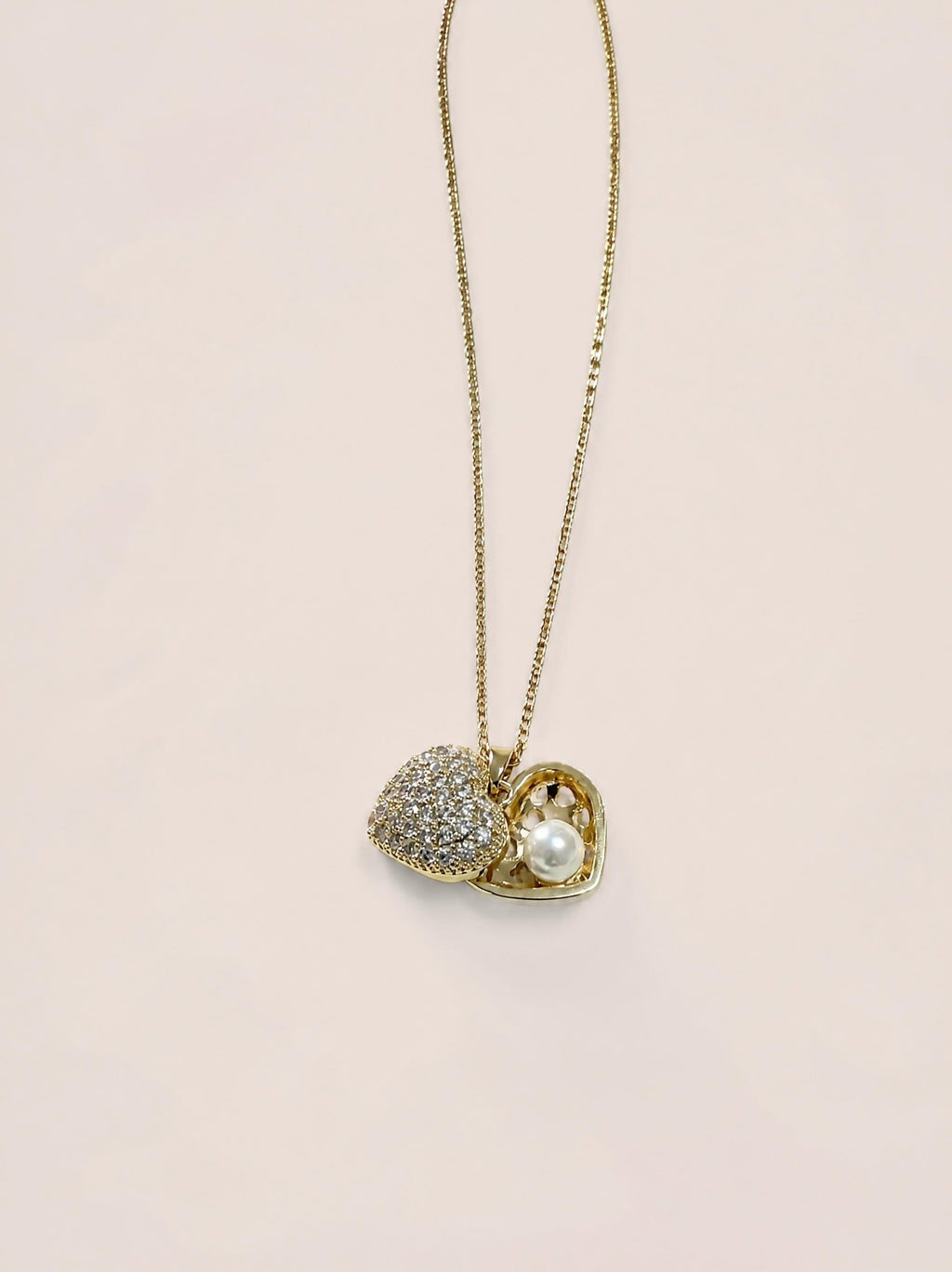 Collier duo cœurs SYERA porté au cou, pendentifs dorés avec zircons et perle